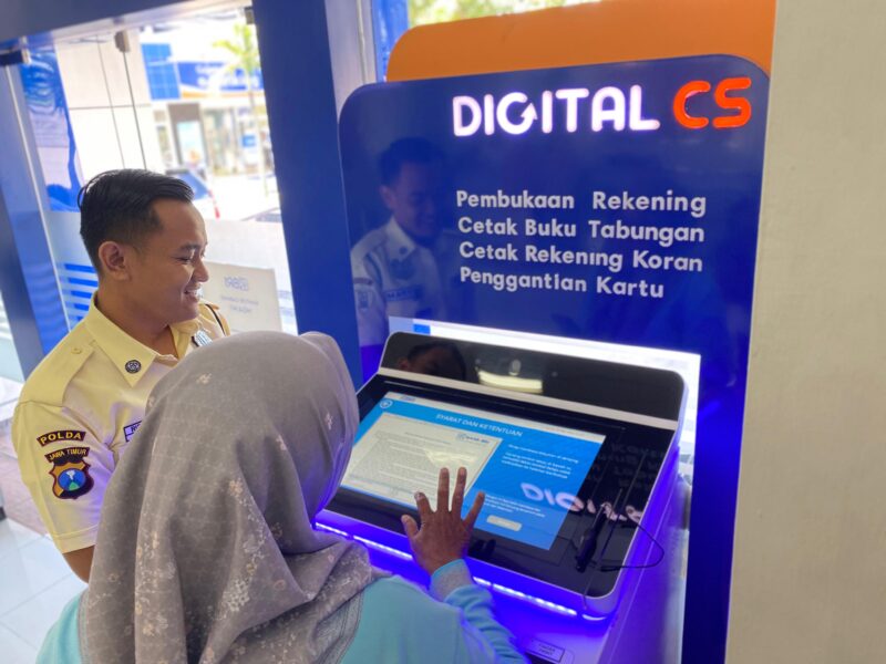 _(Ilustrasi Satpam BRI sedang mengarahkan nasabah menggunakan mesin digital CS)_